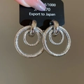 Zilveren oorbellen met dubbele holle ring en gepolijste en matte getextureerde afwerking - In elkaar grijpende dubbele cirkel (Zilver)