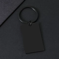 Detailopname van matzwarte rechthoekige metalen sleutelhanger op getextureerd papier - Rechthoek / Zwart