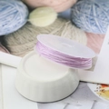 Macro detail of purple braided nylon cord for jewelry making on white spool - 10m / Light Purple