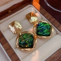 Detalle de pendientes vintage con resina verde y marco dorado en un joyero elegante - Poste de plata - Dorado - Verde