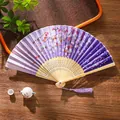 Japanese style folding fan with purple cherry blossom patterns and silk tassel detail - 20 Purple Cherry Rain