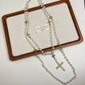 Détail d'un collier de perles multicouche avec des pendentifs croix dorés vintage - Collier croix perle dorée