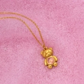 Goldene Bären-Halskette mit rosa Edelstein auf rosa Spitzenhintergrund für Damen - Gold Bär Halskette