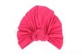 Detail of hot pink elastic turban hat with a signature knot design on white background - Rose Red
