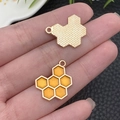Front and back view of golden honeycomb enamel charm held in palm for size reference - Honeycomb