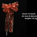 Leuchtende rote Weihnachtsschleife mit Goldsternen, Musiknoten und LED, 32x22,5cm - Rot / Warmweißes Licht