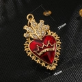 Macro view of a 27mm gold heart pendant with red enamel, crown top and crystal inlay - Sacred Heart Crown Red Style (A0037)
