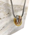 Detailaufnahme eines dreifarbigen Ringanhängers an einer eleganten Schlangenkette - Dreifarbig (Stahl/Gold/Roségold)