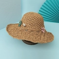Dettaglio ravvicinato di cappello di paglia fatto a mano con tesa ondulata e piccoli fiori - M (56-58cm) / Cachi