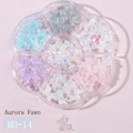 Macro detail of aurora bear and bow nail art charms in a 7-grid petal-shaped organizer box - MH-14 Deer Aurora Style