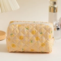 Quilted cotton makeup bag with smiley faces and grid pattern on a warm desktop setting - Yellow Smiley Face