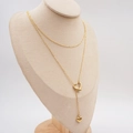 Collana a Y minimalista con pendente a cuore dorato esposta su un busto di colore beige - Collana a Doppio Strato a Cuore