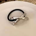 Detail of black elastic hair tie featuring a polished silver X-shaped metal geometric accent - Silver Cross