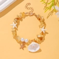 Macro view of shell pendant with pearl and yellow crystal beads on ocean bracelet - Yellow Stone Shell Style