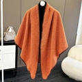 Close-up of orange textured knit shawl featuring dark brown decorative stitching detail - Bright Orange