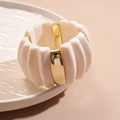 Detalle de la pulsera rígida de acrílico blanco crema con espaciadores dorados - Brazalete-Color Plata