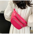 Detail der fuchsiafarbenen PU-Leder-Brusttasche mit Silberkette auf weißem Kleid - Rosarot