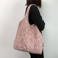 Detail der rosa floralen Jacquard-Textur an einer minimalistischen Tragetasche am Model - Lotusrosa Reliefblume