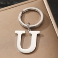 Polished silver metal keychain with uppercase letter U pendant on textured brown surface - Letter U