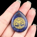 Lapis lazuli teardrop pendant featuring a golden tree of life carving on dark blue stone - Lapis Lazuli