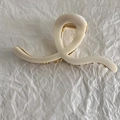 Close-up of a white cream-colored heart-shaped hair claw clip with gold metal spring detail - S-Shaped Line Style
