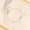 Detail of pink beaded bracelet with a white heart evil eye pendant on a marble tray - 5# Pink Bracelet