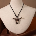 Detail of Maori fish hook resin pendant necklace on mannequin with woven black rope - Bull Head