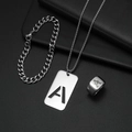 Nahaufnahme eines silbernen Titanstahlschmucksets mit eingraviertem Buchstaben A auf Anhänger - Set A