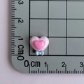 Dettaglio di un cuore in resina rosa con fiocco blu su una griglia di misurazione - Doppio Cuore con Fiocco