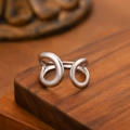 Polished silver stainless steel open ring with interlocking hollow lines on wood surface - Double Ring Cross / Steel