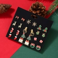 Macro view of 12-pair Christmas earring set with festive motifs on black display card - 12 Pairs/Set Christmas Tree Snowman Sock