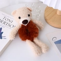 Detail view of a cute beige plush bear hair tie on a soft brown elastic scrunchie band - Coffee
