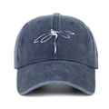Close-up of a washed denim baseball cap featuring a white dragonfly print on deep blue fabric - One Size / Navy Blue