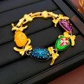 Detailaufnahme eines Vintage-Goldarmbands mit bunten Emaille-Eiern und Schleifenakzenten - Faberge Ei Emaille Armband (Gold Mehrfarbig)