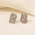 Macro di orecchini a fiocco geometrici in argento su elegante sfondo in tessuto - Stile Irregolare Fluido Lava - Argento (D198-S)