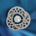 Macro detail of rose gold floral brooch with central pearl and sparkling rhinestones - Camellia Brooch