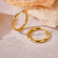 Minimalist gold round hoop earrings with a polished metallic finish on stone surface - Inner Diameter 18mm / Gold