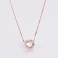 Primer plano detallado del collar corazón de oro rosa con piedras de circón sobre blanco - Oro rosa
