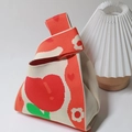 Knitted bucket wrist bag featuring red heart patterns and green leaf on beige fabric - Tulip Orange