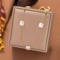 Detail of golden tassel necklace featuring square pearls on a luxury jewelry box - Square Pearl (H1075) / Gold