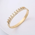 Bracciale rigido a corona dorata con cristalli pavé mostrato in prospettiva laterale - Oro