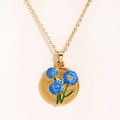 Detalle del collar vintage dorado con colgante de tulipán en esmalte azul sobre blanco - Azul
