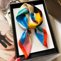 Detailed view of colorful printed silk scarf styled as an elegant necktie bow - 70x70cm / Orange Border