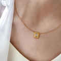 Close-up of minimalist gold zircon necklace with a rectangular cut stone on a model - Rectangular Zirconia