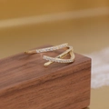 Detailed macro view of an 18K gold-plated triple-layered ring with zircon and pearls - Adjustable Open / Cross Open Ring