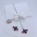 Dettaglio di ciondoli a ape con zirconi rosa, blu e neri su una elegante confezione regalo - #4 (Ciondolo Singolo - Ape Argentata)