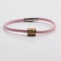 Rosa Lederarmband mit goldener Zirkonia-Perle und silbernem Magnetverschluss auf weißem Grund - Rosa