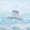 Light blue acetate hair claw clip with marble texture over a summer ocean background - Translucent Sky Blue