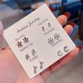 Hand holding a card featuring six pairs of assorted fashion stud earrings for a weekly set - Colorful Flower Leaf Snowflake Combination (E1350-1)