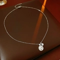 Dettaglio macro della collana con ciondolo a stella in argento e zirconi su sfondo pelle - Argento